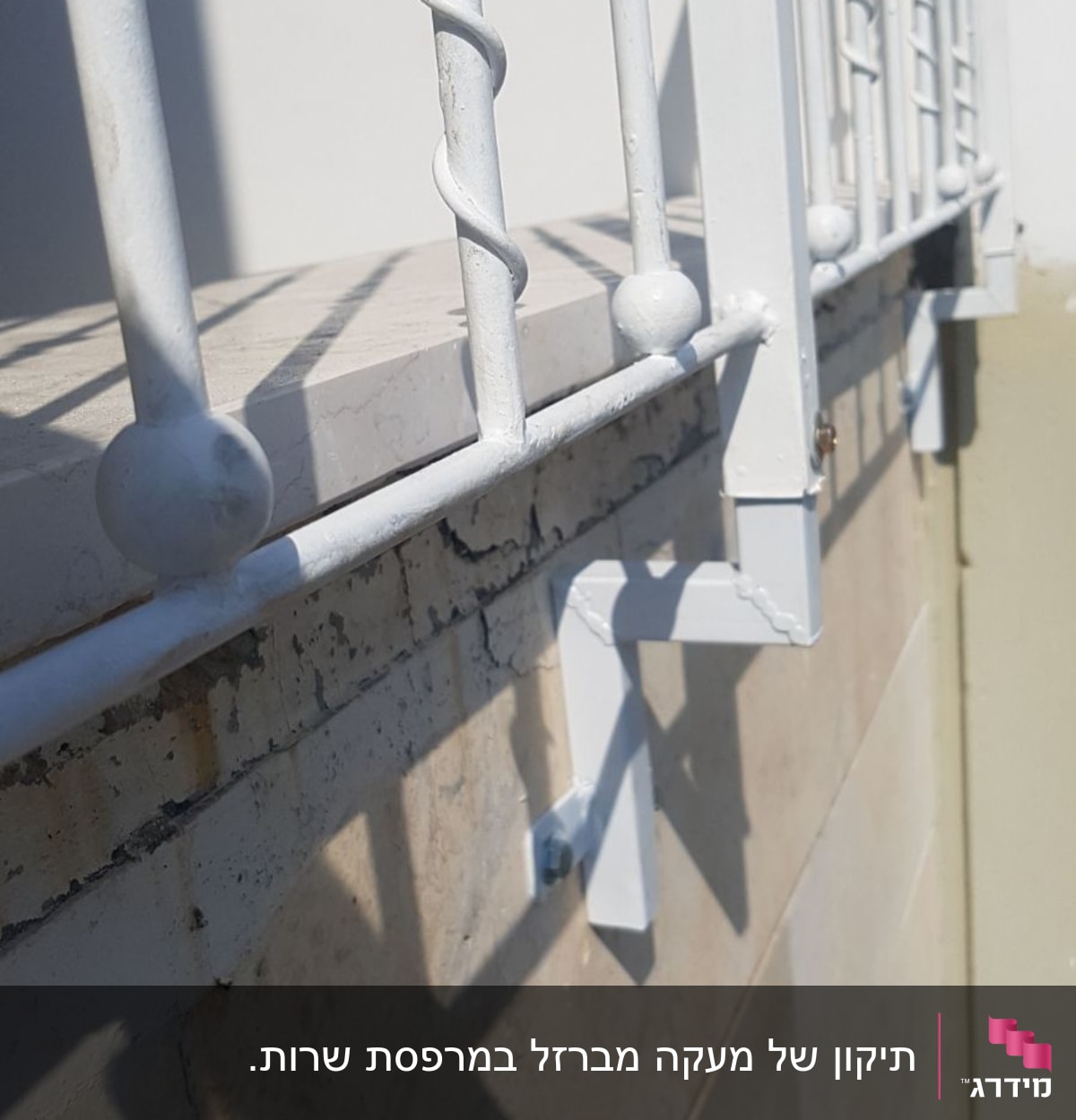 מעקה מתכת לבן עם עיטורים על קיר אבן